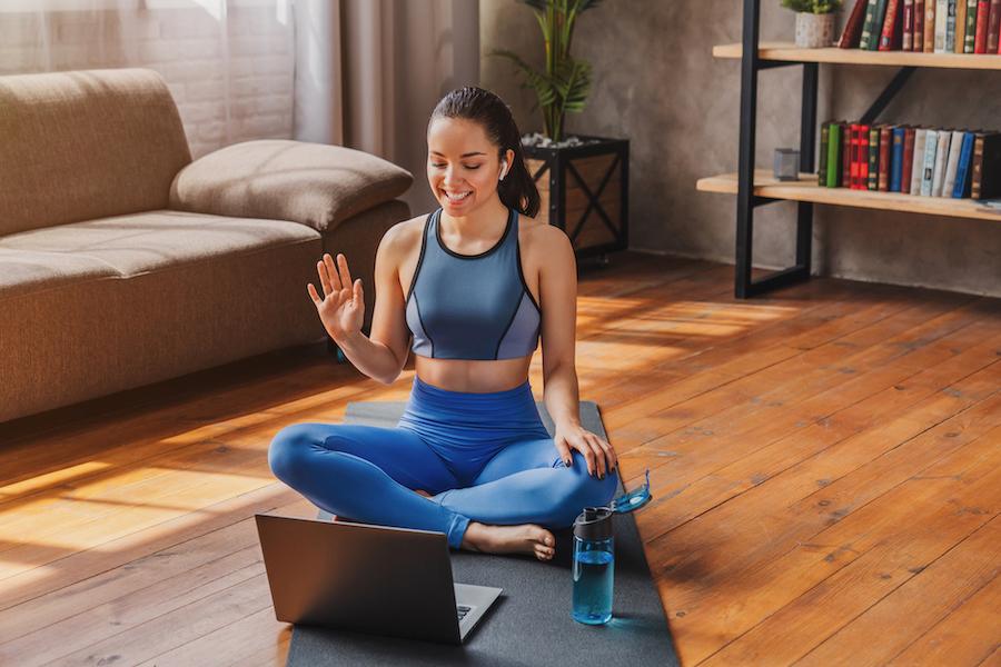 A person waving to their laptop in Easy Pose