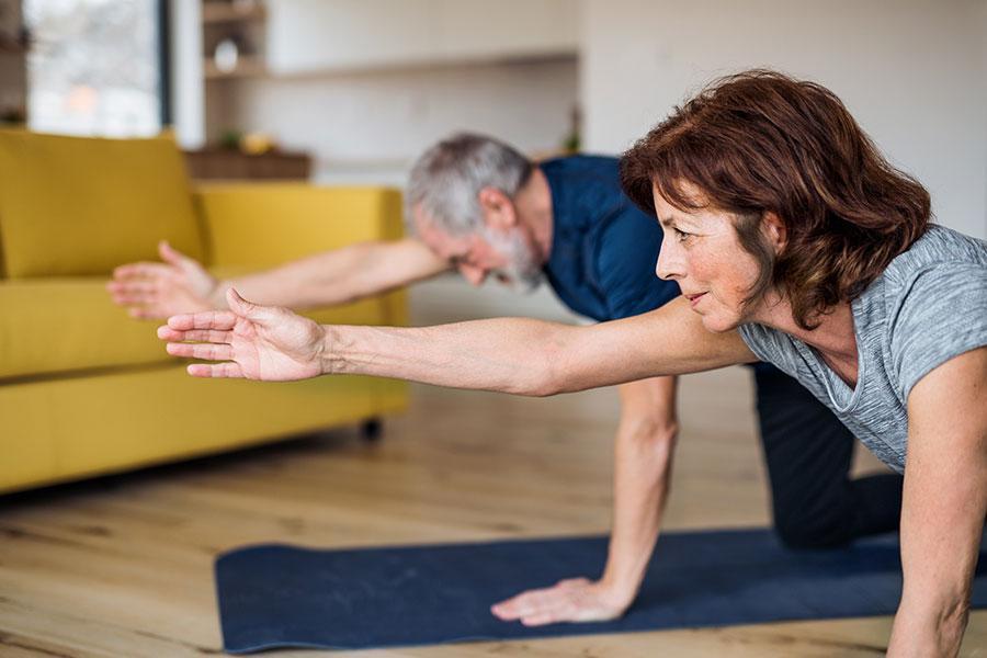 two people doing yoga together at home on mats