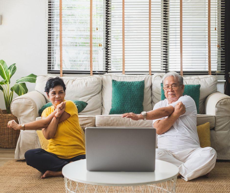 woman and man doing stretching in front of a laptop