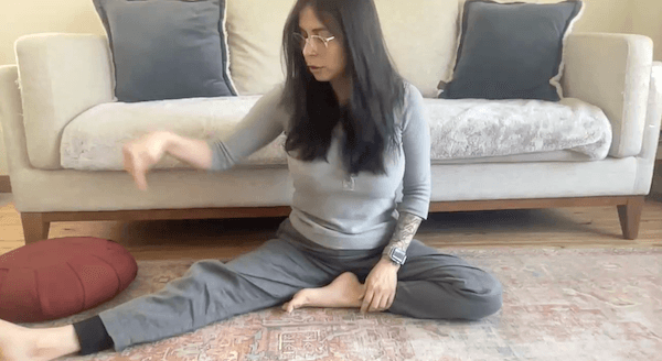 Ompractice teacher Nadja Villegas on floor with leg folded inwards