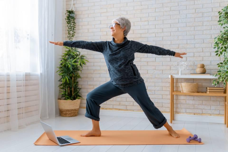 A smiling woman doing a warrior yoga pose