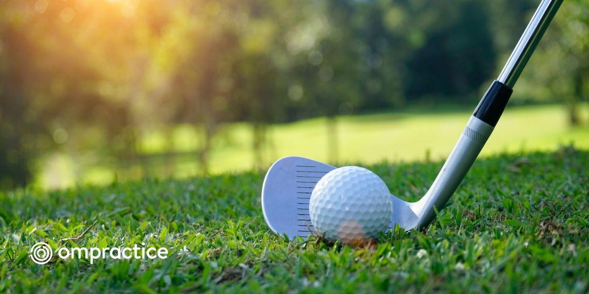 a picture of a golf club and golf ball with the ompractice logo overlaid on the grass