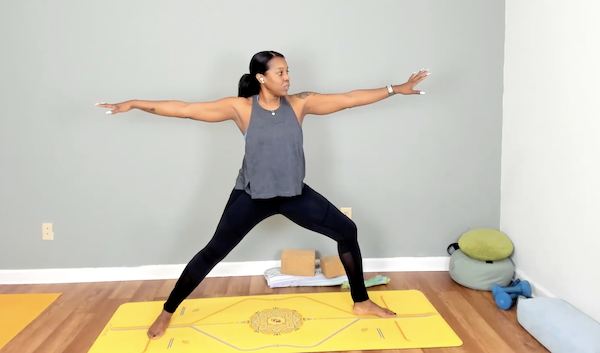 Chanel Sledge extending arms in warrior on a mat