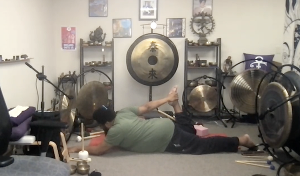 Ompractice teacher Reggie Hubbard stretching on a mat