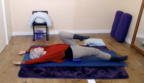 Ompractice teacher Beth Ciesco lying on mat stretching