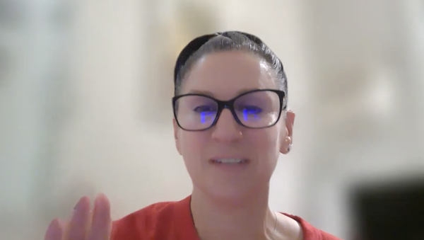 Annie Okerlin, smiling againt a textured gray background