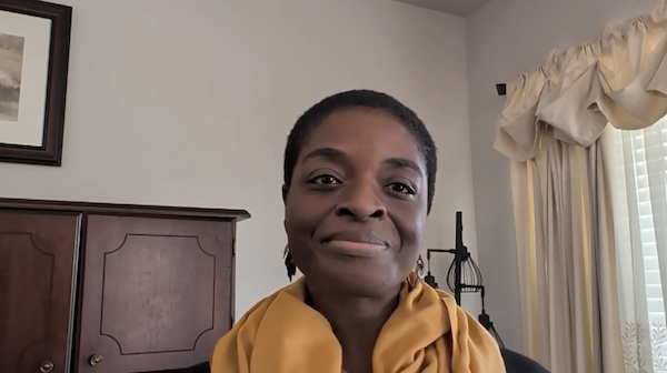 Ompractice teacher Alynthia Penn wearing a yellow scarf seated