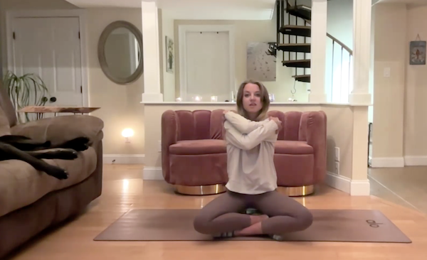 Ompractice teacher Dannika Ross does a seated pose on her mat