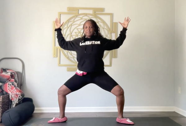 Ompractice teacher shanna small stands on a mat with arms in cactus