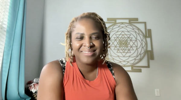 Ompractice teacher Shanna Small in yellow tank headshot with hands in prayer