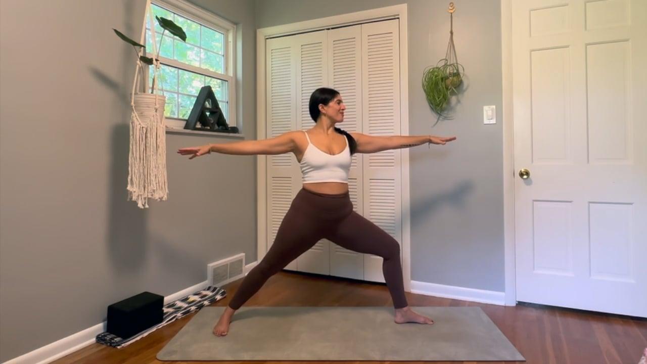 Ompractice teacher Lisa demonstrating warrior two pose with arms outstretched