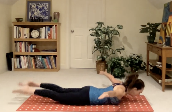 Ompractice teacher Jayne Schmitz doing Pilates teaser on Pilates mat on grass