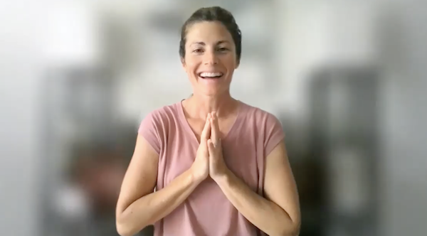 Ompractice teacher Sarah Plummer Taylor seated in side stretch
