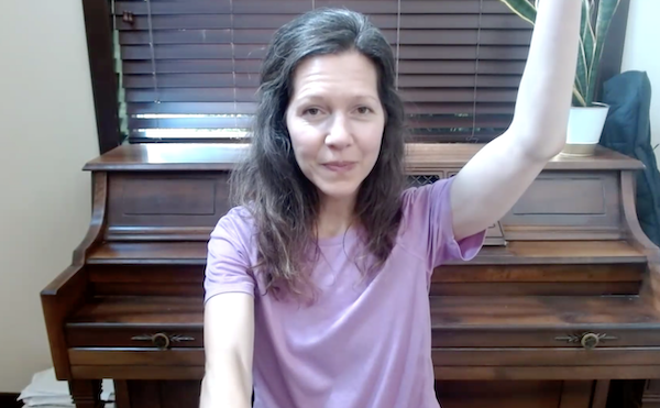 Ompractice teacher marie seated with an arm raised