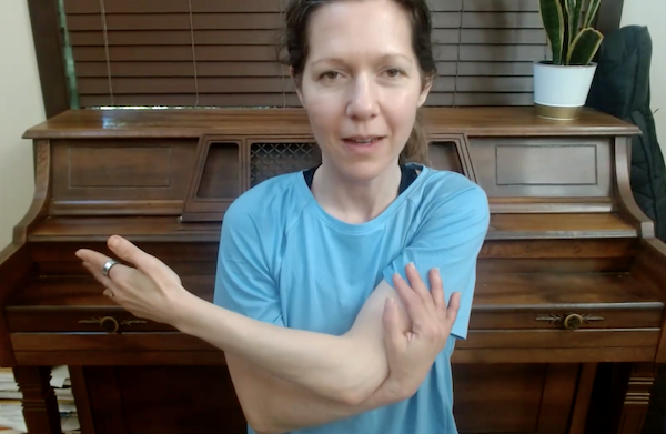 Ompractice teacher marie seated doing an arm stretch