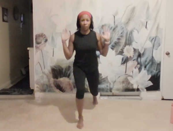 Ompractice teacher Charisse Burrus in a standing pose with arms pushing forward