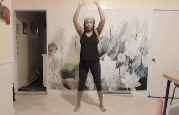 Ompractice teacher Charisse Burrus standing with her arms overhead