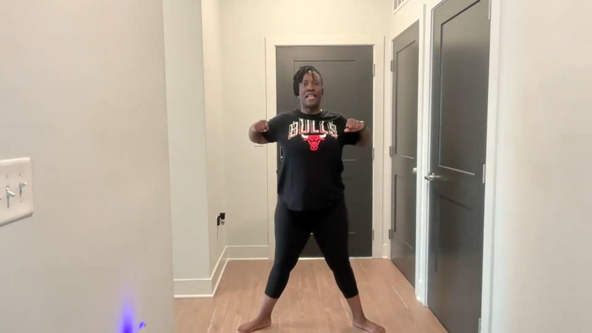 Ompractice teacher Tasha Edwards standing with arms extended forward