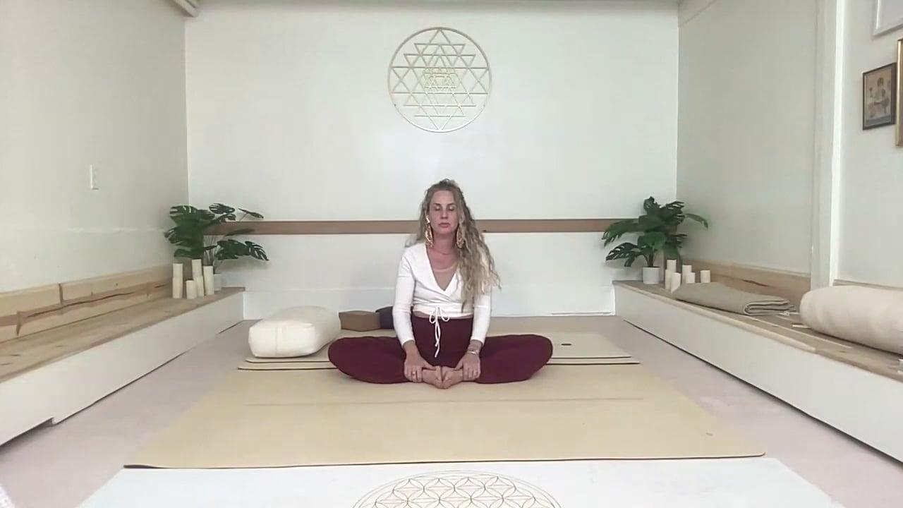 Ompractice teacher Prema Posner seated on her mat