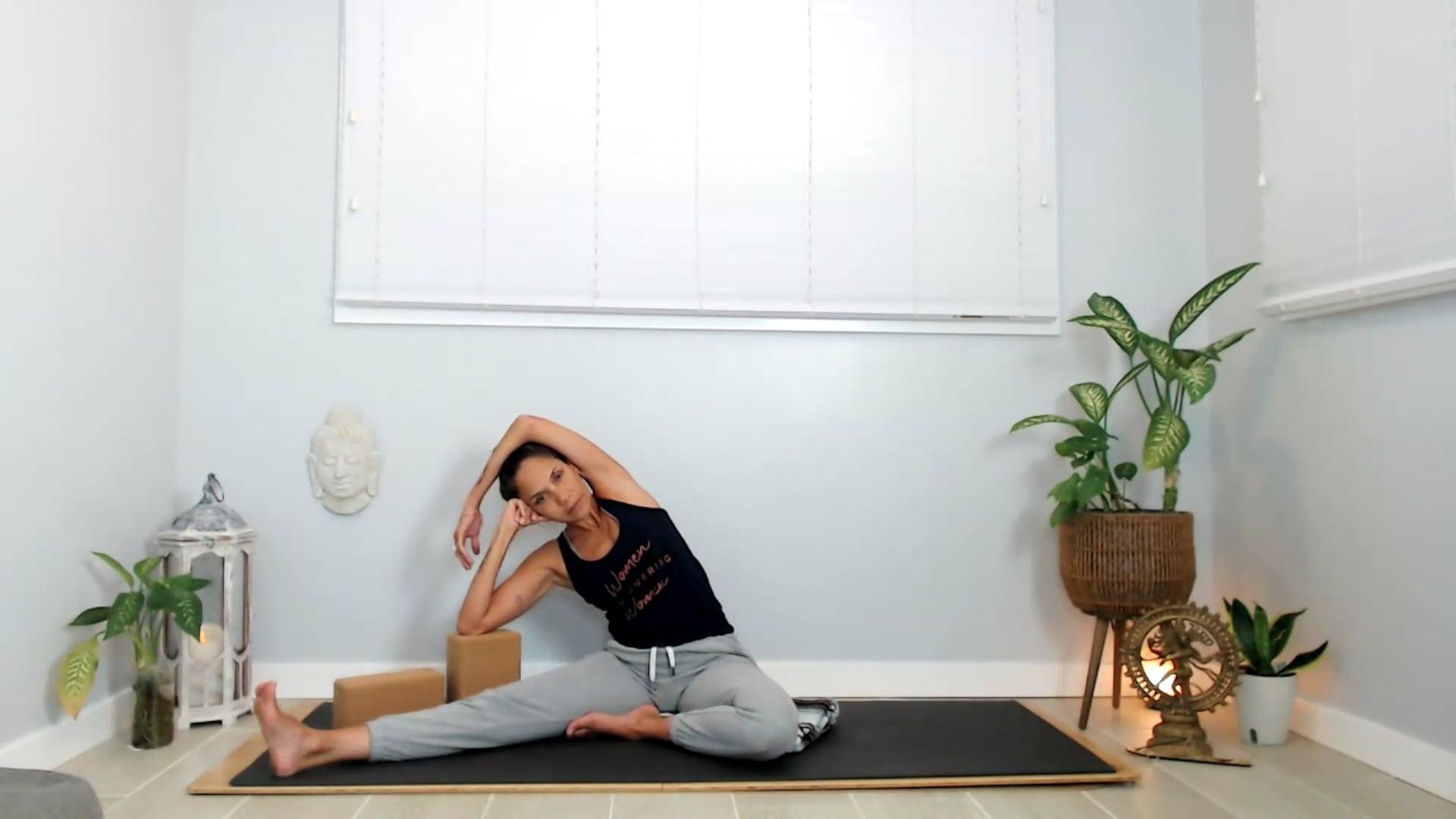 Ompractice teacher Yely Rivas sitting on the mat in a bending pose