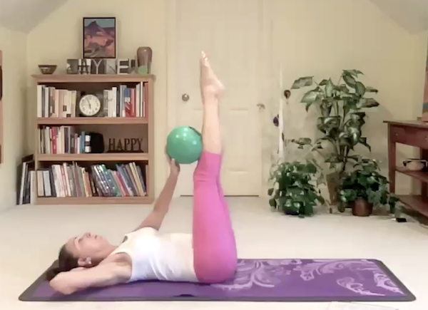 Ompractice Teacher Jayne Schmitz raising leg with pilates ball