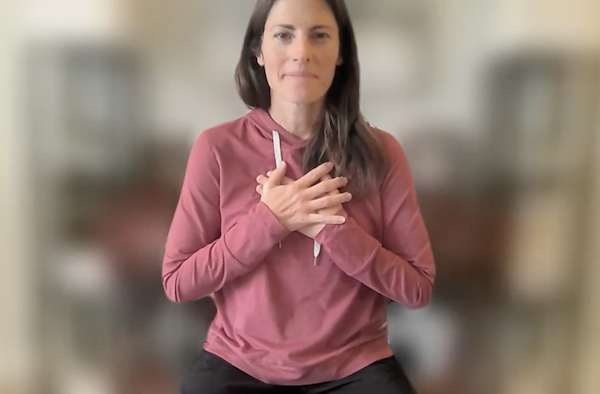 Ompractice teacher Sarah Plummer Taylor seated with hands at chest