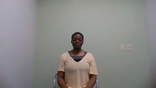Ompractice teacher Alynthia Penn sitting in a white t shirt