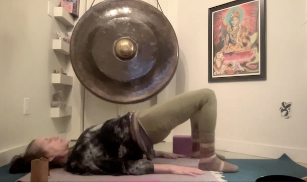 Ompractice teacher Emily Wiadro lying on back on a mat