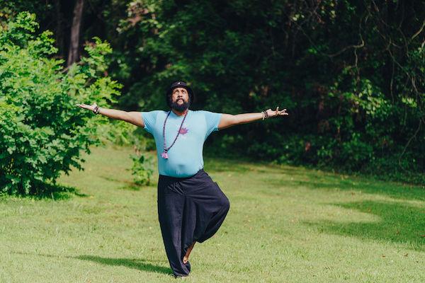Reggie Hubbard in tree pose, surrounded by nature