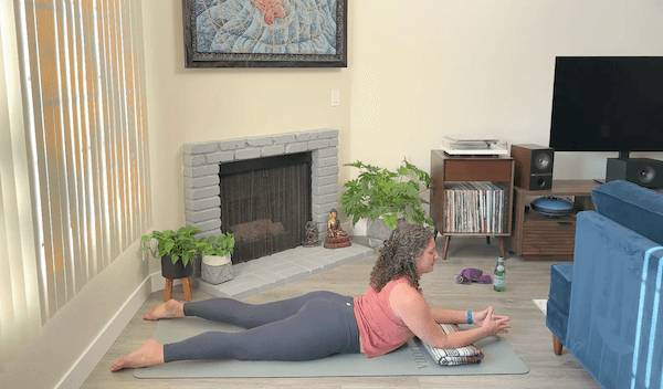 Ompractice teacher niki on mat on belly